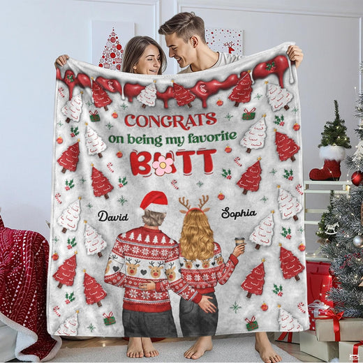 Holiday couple in reindeer sweaters with frosted Christmas tree cookies and holiday greeting, view 1.