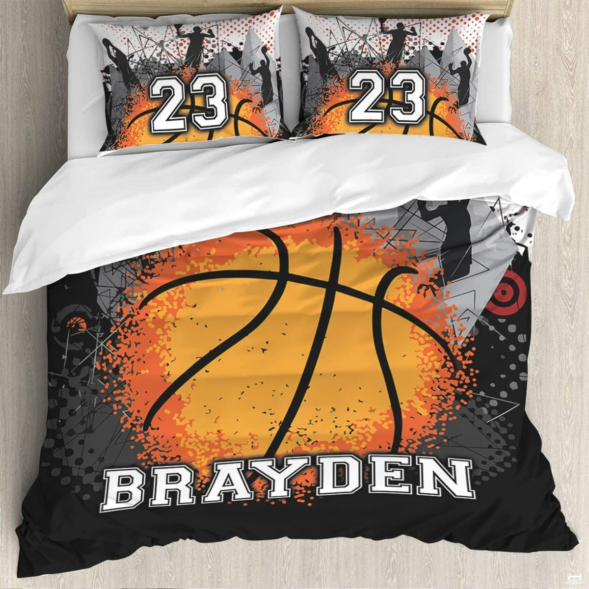 Close-up perspective of vibrant orange splatter basketball graphics and dark player silhouettes on bedding