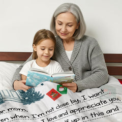Detail of festive greeting calligraphy and cottage entryway illustration on a holiday blanket