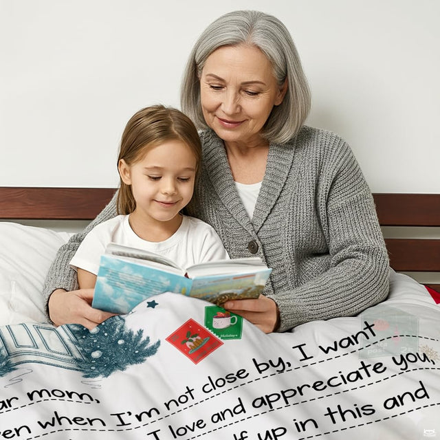 Detail of festive greeting calligraphy and cottage entryway illustration on a holiday blanket