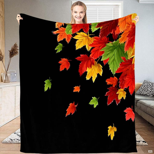 Vibrant cascading leaves throw blanket draped across contemporary black sofa