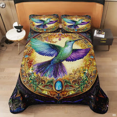 Overhead view of jewel-tone hummingbird design in an ornate golden medallion