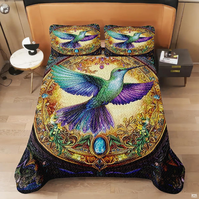 Overhead view of jewel-tone hummingbird design in an ornate golden medallion