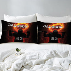 Side angle view of athletic winter sports bedding showing amber orange and midnight black tones on mattress