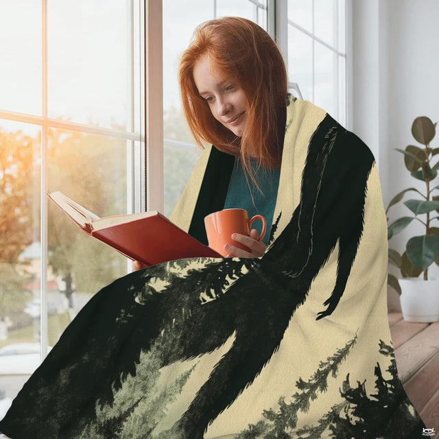 Lifestyle display of the Bigfoot misty forest throw blanket beside a sunny window.