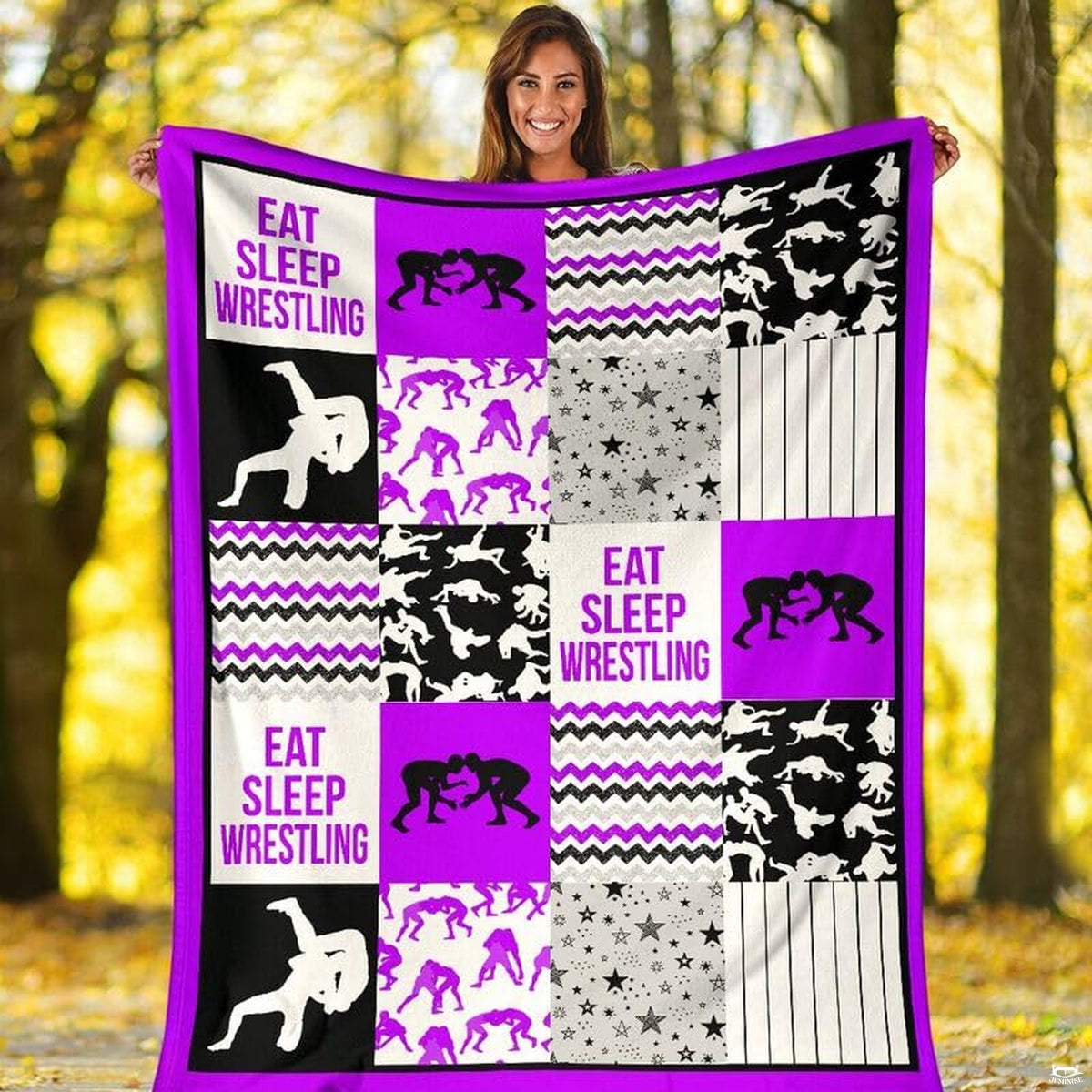 Purple wrestling sports throw blanket styled across a bed in a modern bedroom setting.