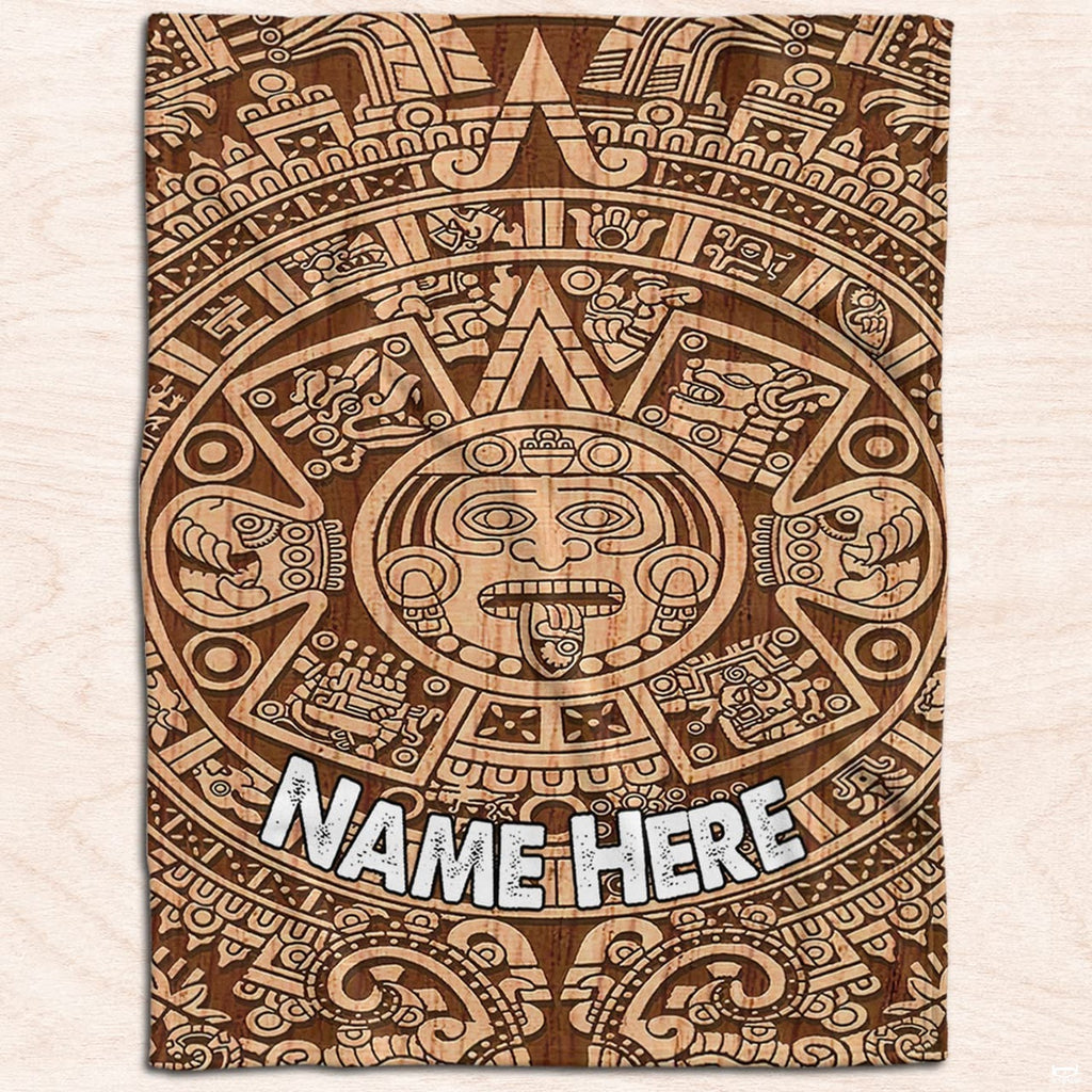 Burnt wood Aztec sun calendar graphic textile displayed flat on light wood planks.