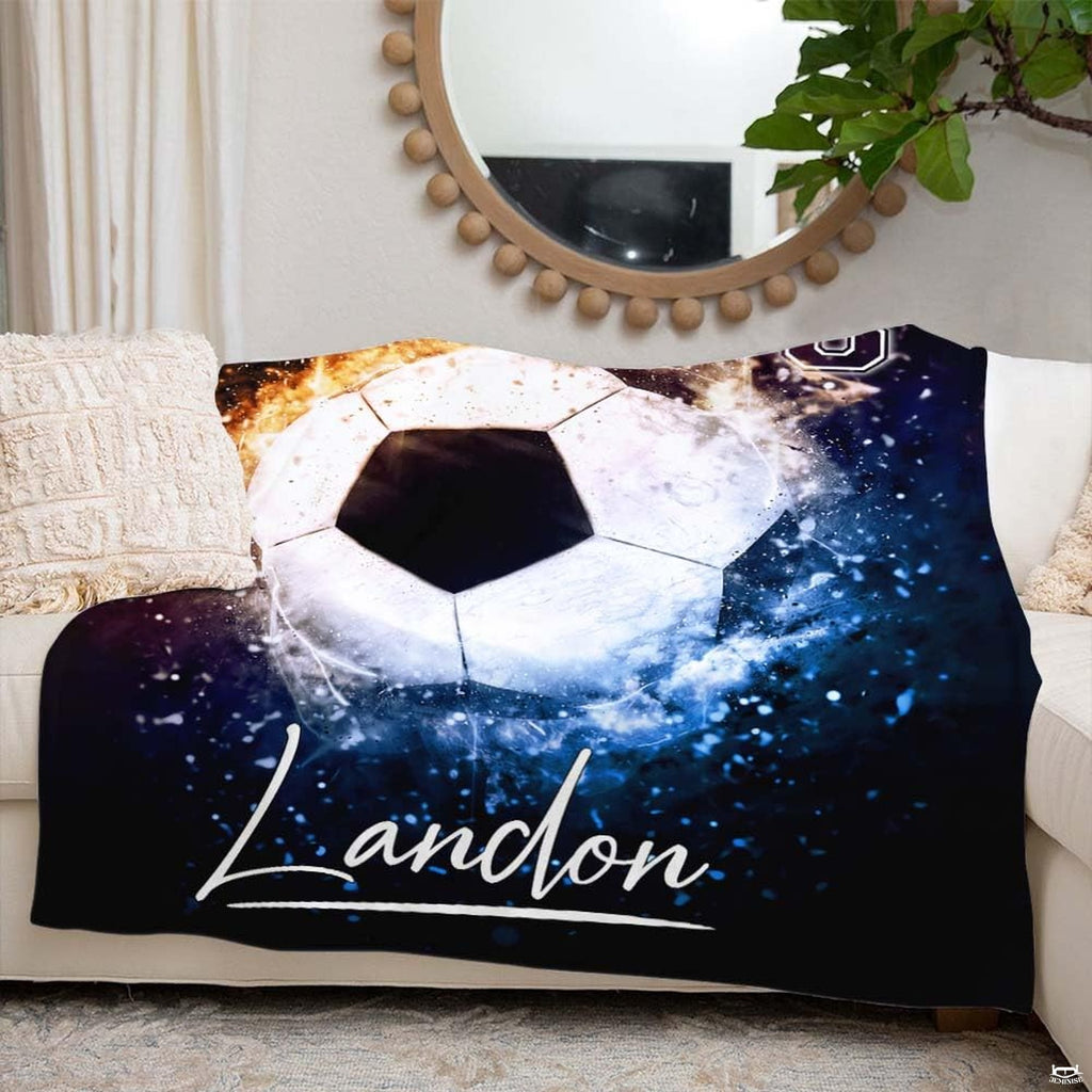 Lifestyle bedroom view showing the soccer ball sports throw blanket styled across a bed.
