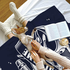 Detailed linework of maritime helm, star accents, and banner on navy bedding.