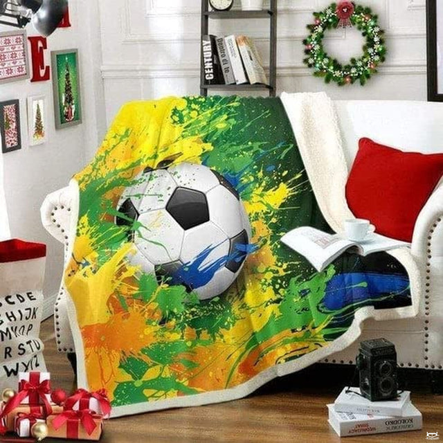 Living room sofa setting displaying the soccer paint splatter sports throw blanket draped on furniture.
