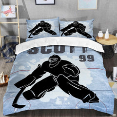 Top-down view of steel blue ice hockey goalie bedding set arranged neatly on a youth bedroom mattress