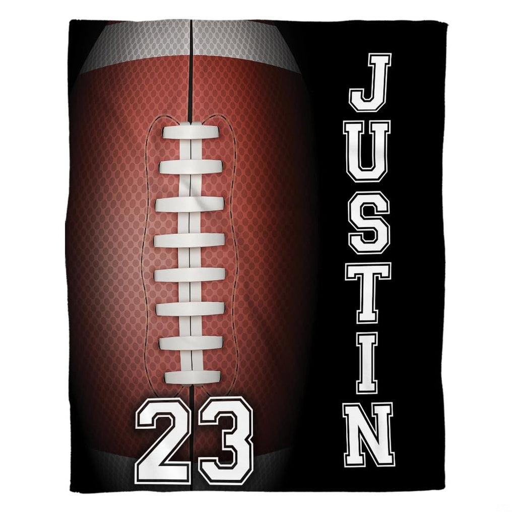 Woman holding open American football throw blanket showing gridiron laces and varsity typography