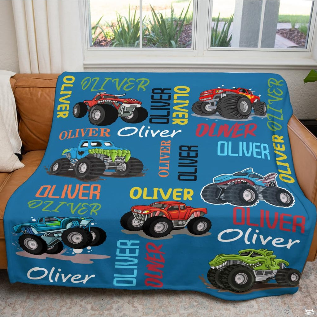 Folded monster trucks throw blanket revealing bright blue backdrop and cartoon vehicle graphics