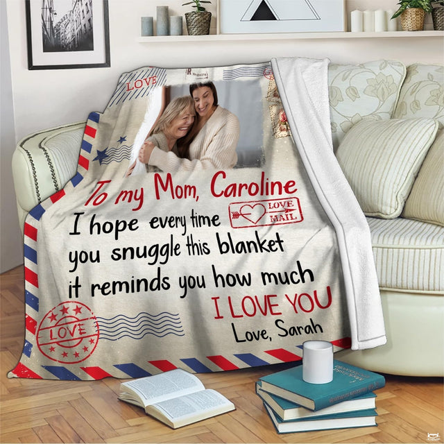 Vintage airmail throw blanket arranged across beige living room sofa beside accent pillows