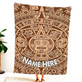 Woman standing indoors holding up carved wood Aztec sun stone graphic textile.