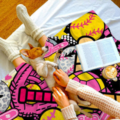 Draped perspective of softball collage throw blanket highlighting hot pink and yellow tones.