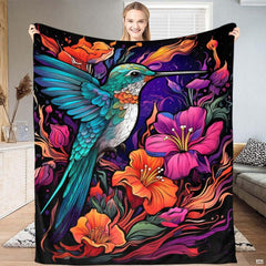 Vibrant hummingbird in mid-flight surrounded by magenta tropical blossoms and turquoise leaves on dark background.