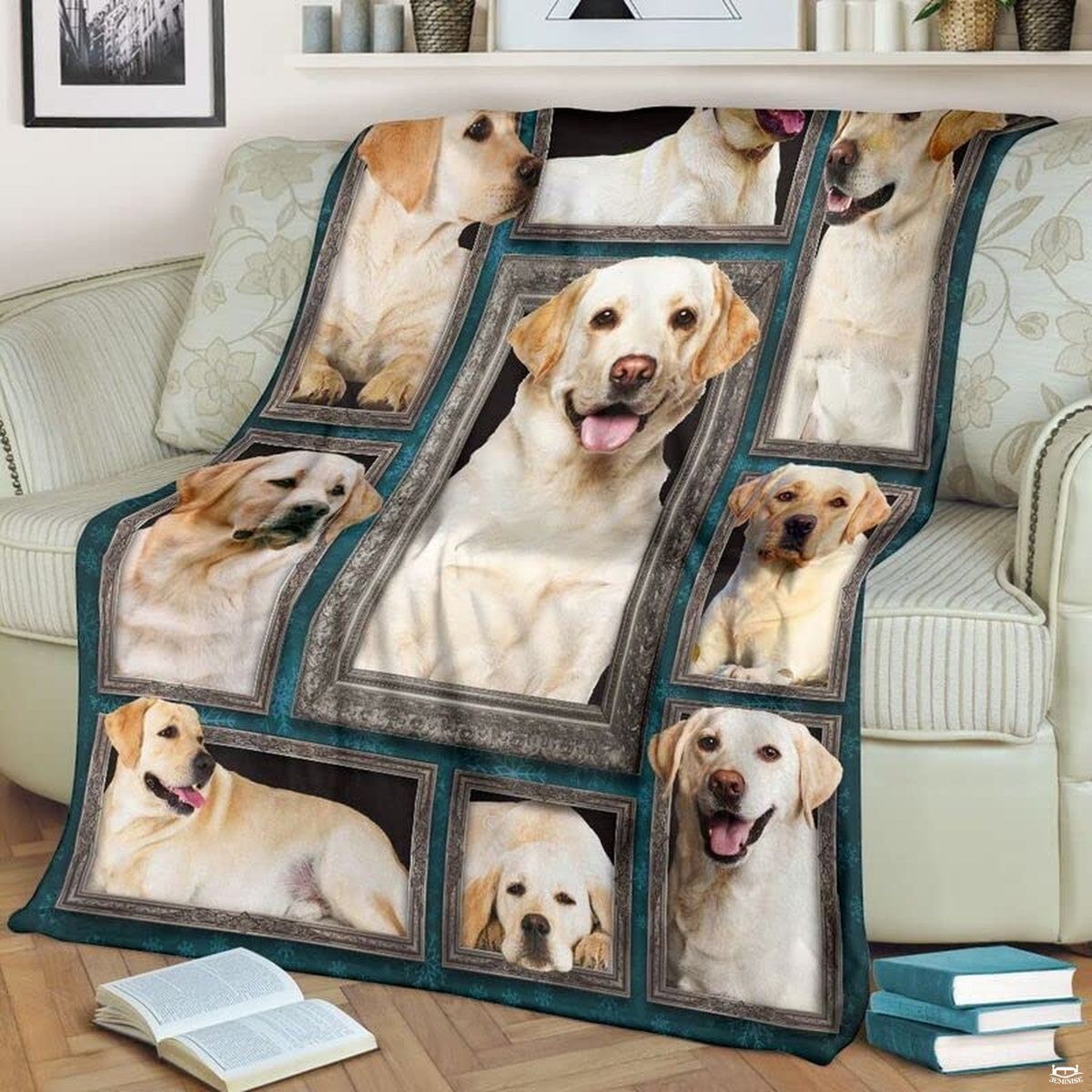 Yellow Labrador Retriever throw blanket styled across a living room sofa near stacked books and a cup.