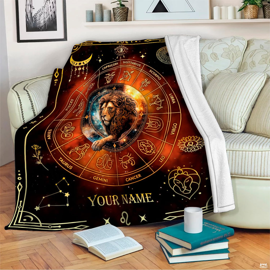 Cosmic zodiac lion blanket draped across an indoor living room couch next to stacked books.