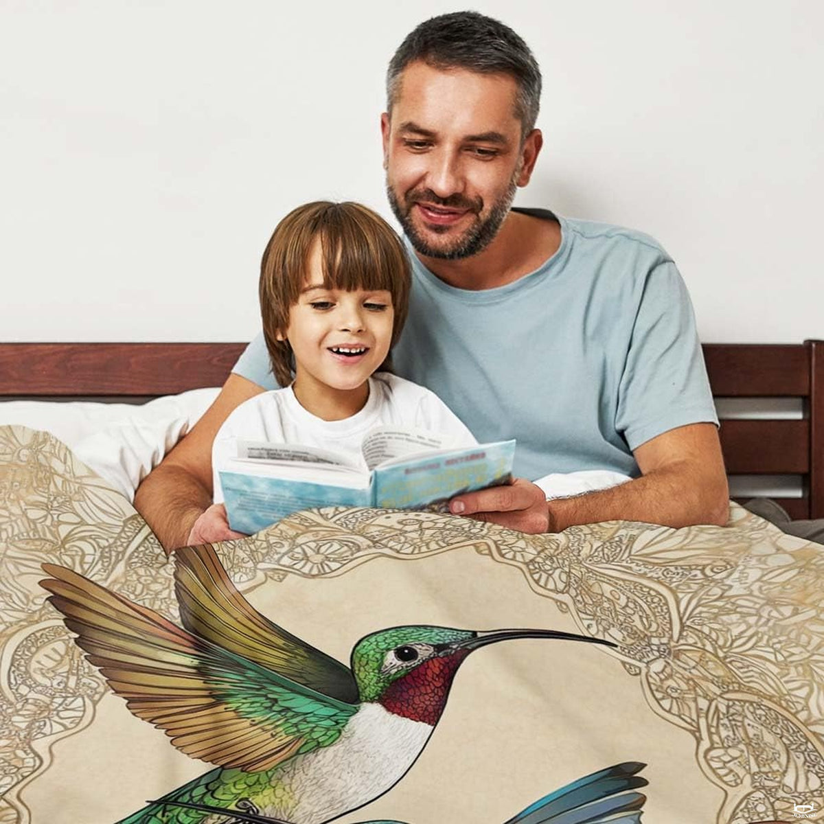 Ivory hummingbird throw blanket draped over an upholstered bed.