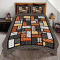 Halloween patchwork bedding featuring mosaic blocks of pumpkins, black cats, ghosts, and spiderwebs