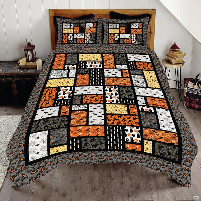 Halloween patchwork bedding featuring mosaic blocks of pumpkins, black cats, ghosts, and spiderwebs
