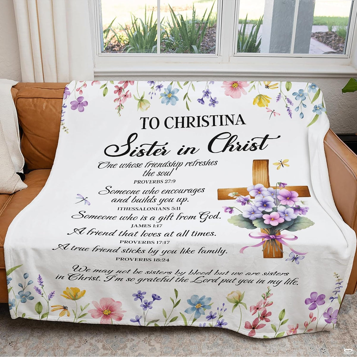 Botanical garden bedding with central wooden cross accent tied in a lavender ribbon on an off-white background.