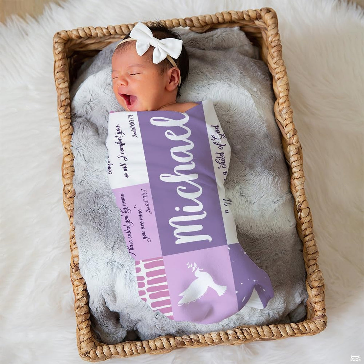 Sleeping newborn infant wrapped in lavender patchwork print resting inside a woven wicker basket.