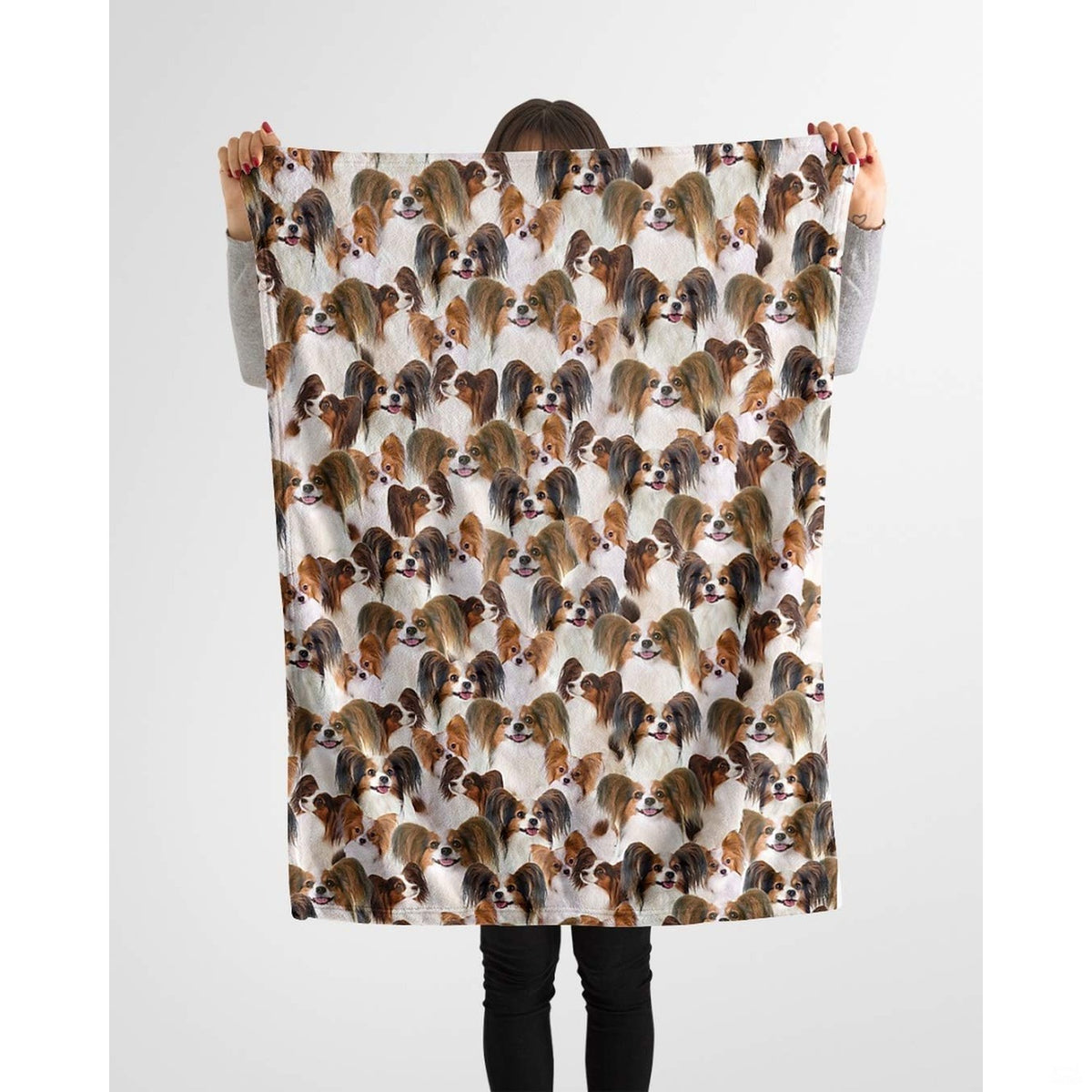 Papillon dog lover throw blanket styled across a couch in a bright living room.