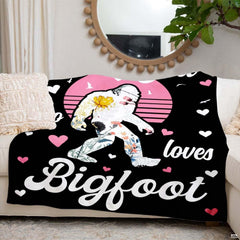 Folded floral Bigfoot retro sunset throw blanket resting on wooden table displaying sunset graphic