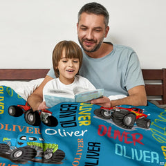 Close-up perspective of shark-themed monster truck and oversized treads on colorful throw blanket