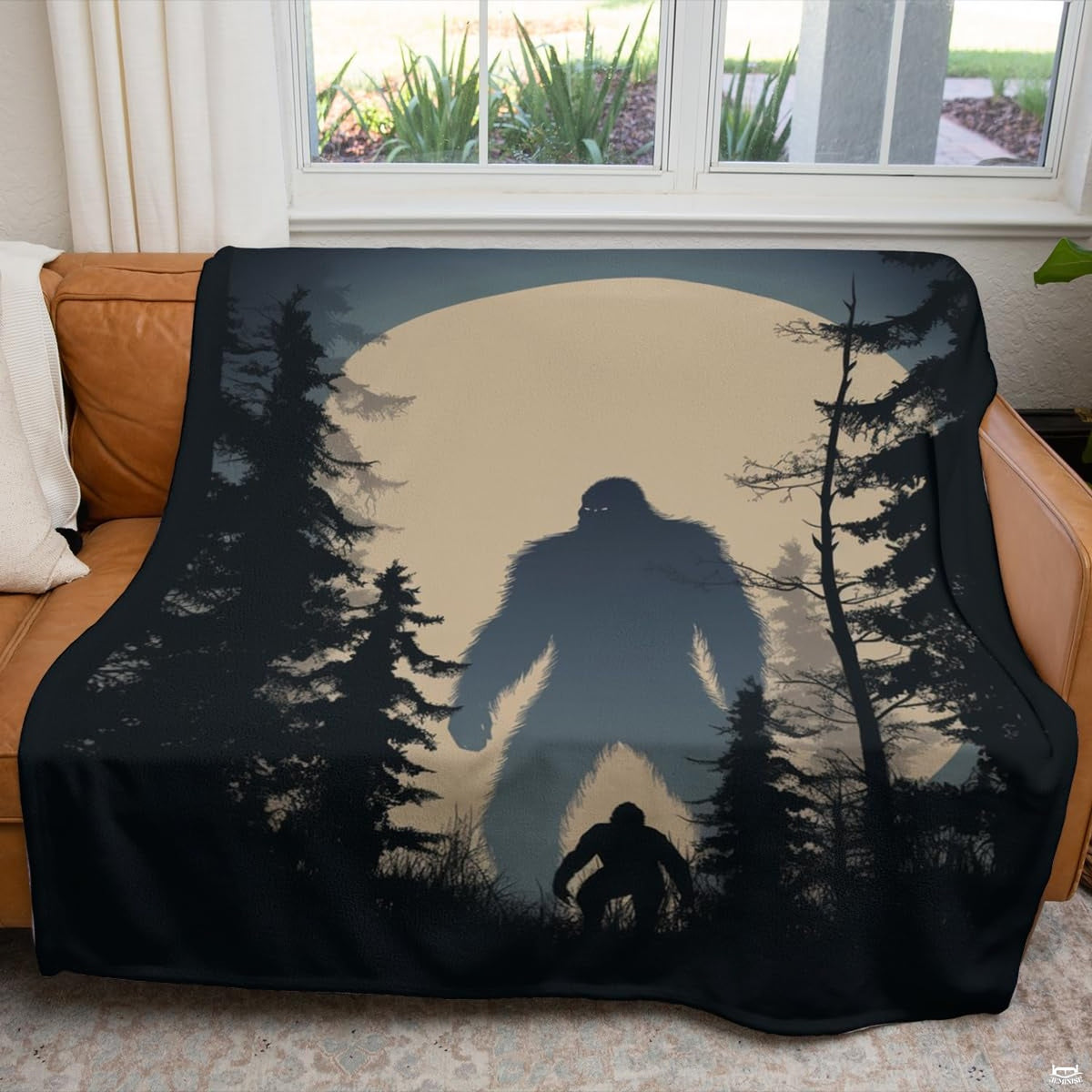 Nocturnal Bigfoot forest blanket styled over a living room couch.