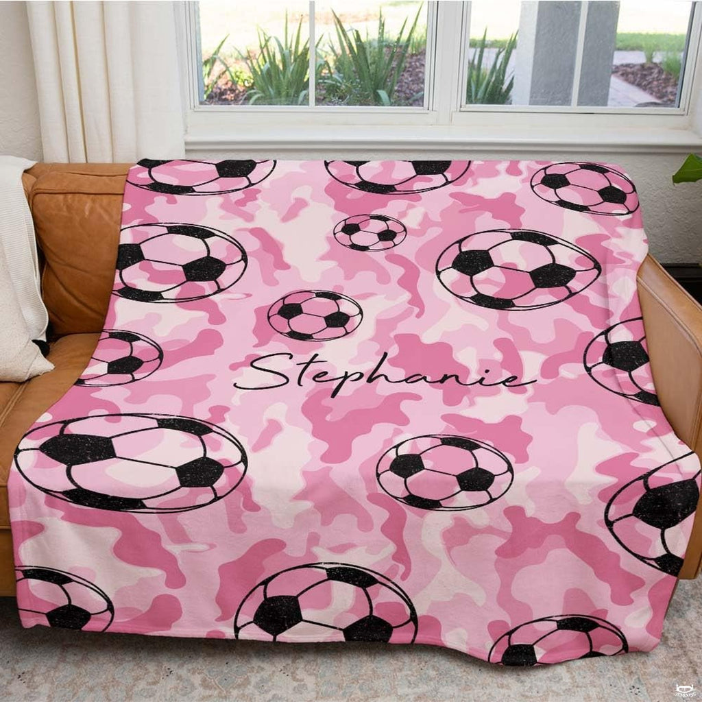 Close view of floating soccer balls on pink camouflage background