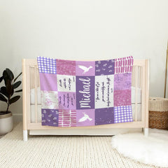 Lavender patchwork piece draped over the wooden railing of a light timber nursery crib.