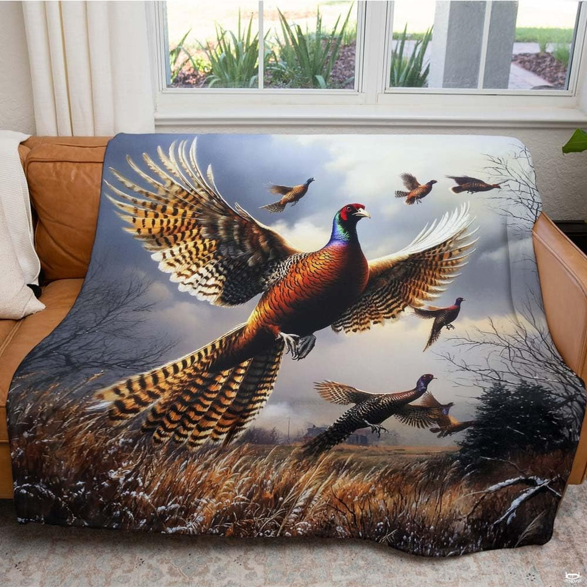 Folded flushing pheasants throw blanket resting on wooden table displaying copper and amber colors