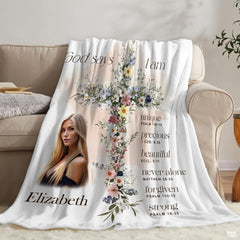 Inspirational floral cross scripture blanket styled over couch in bright natural living room.