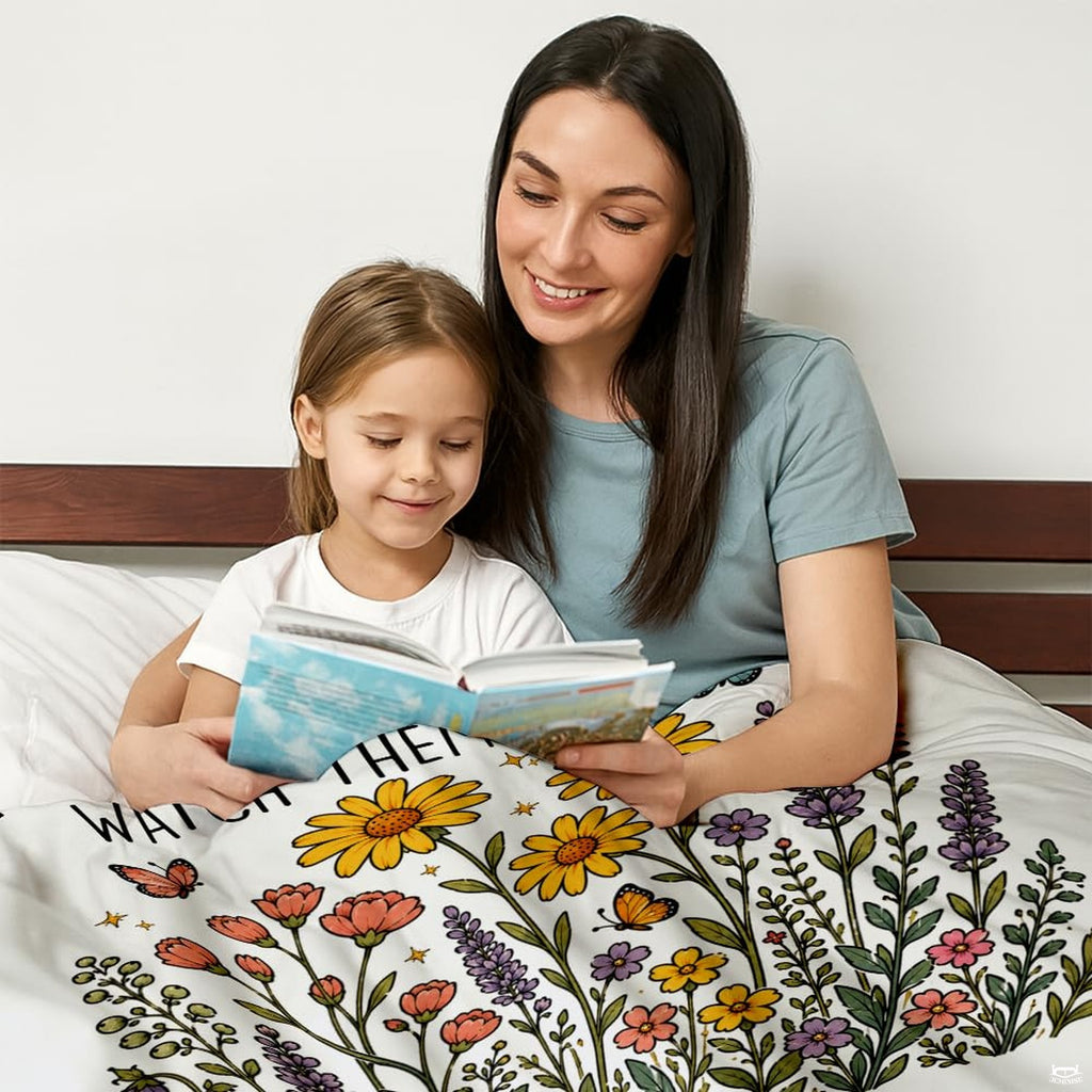 Folded teacher appreciation wildflower throw blanket resting on wooden table displaying floral print