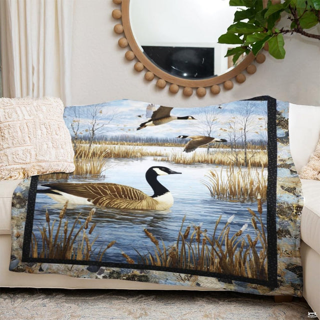 Canada goose floating on marsh water with flying geese and autumn cattails, view 2.