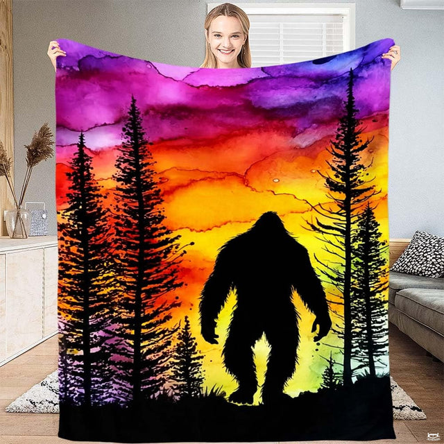 Bigfoot sunset pine forest throw blanket featuring Sasquatch silhouette and vibrant watercolor sunset sky