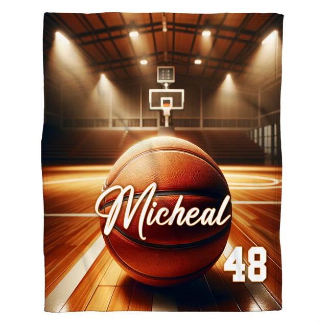 Dramatic basketball resting on polished hardwood court floorboards under glowing arena spotlights.
