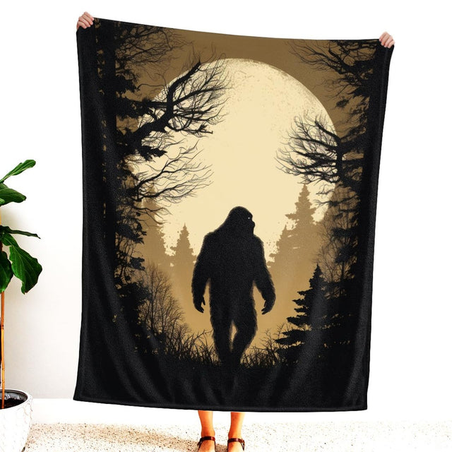 Close-up of Bigfoot silhouette and glowing amber moon artwork.