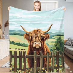 Rustic farmhouse bed display with painted Highland cow illustration, yellow meadow wildflowers, and rolling pastures.