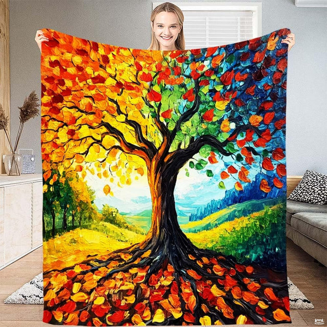 Model displaying throw blanket with vibrant impasto oil painting tree showing golden and cobalt foliage