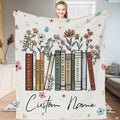 Wildflower books blanket displaying vintage book spines blooming with meadow flowers on cream backdrop.