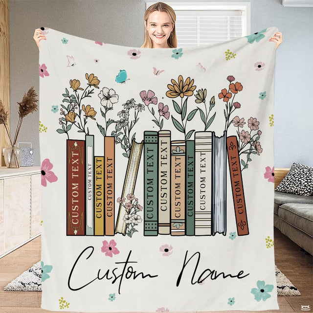 Wildflower books blanket displaying vintage book spines blooming with meadow flowers on cream backdrop.