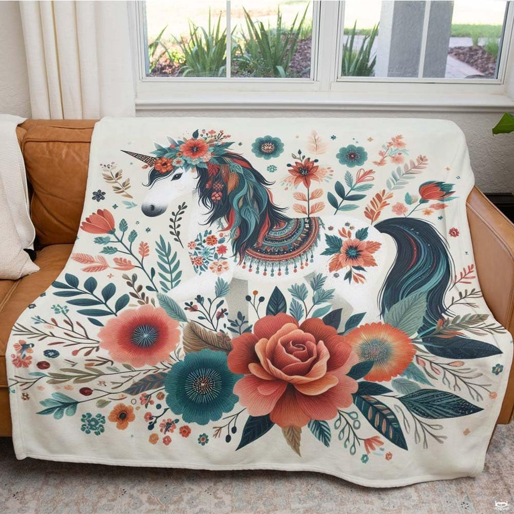 Folded corner presentation of floral unicorn folk blanket showing colorful botanicals