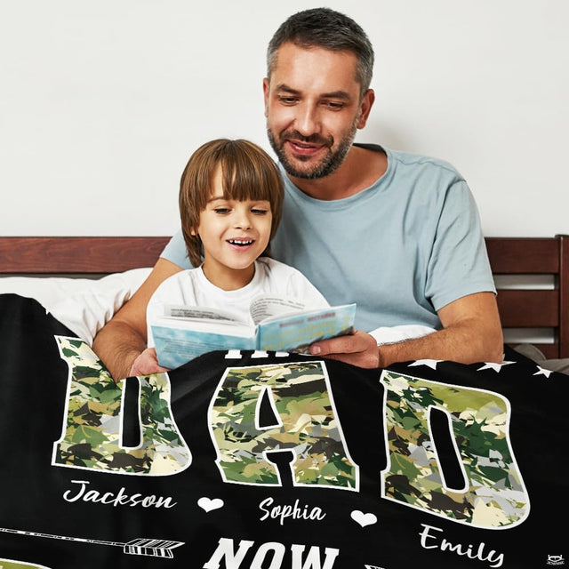 Living room display showing camouflage typography throw blanket styled on neutral furniture.