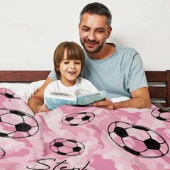 Soccer balls pink camo artwork blanket folded on living room chair