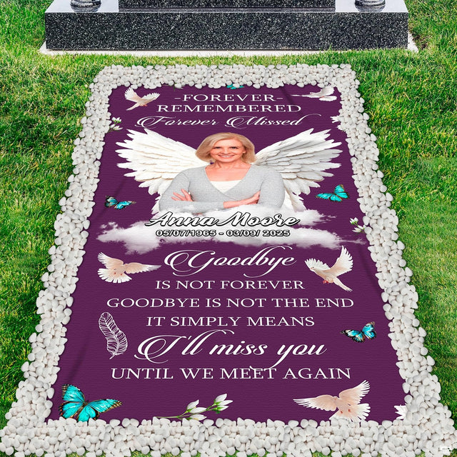Angel grave blanket installed across cemetery plot turf bordered by clean white pebbles