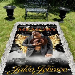Cemetery lawn memorial setting showcasing the angel wings tribute blanket with decorative stone border.